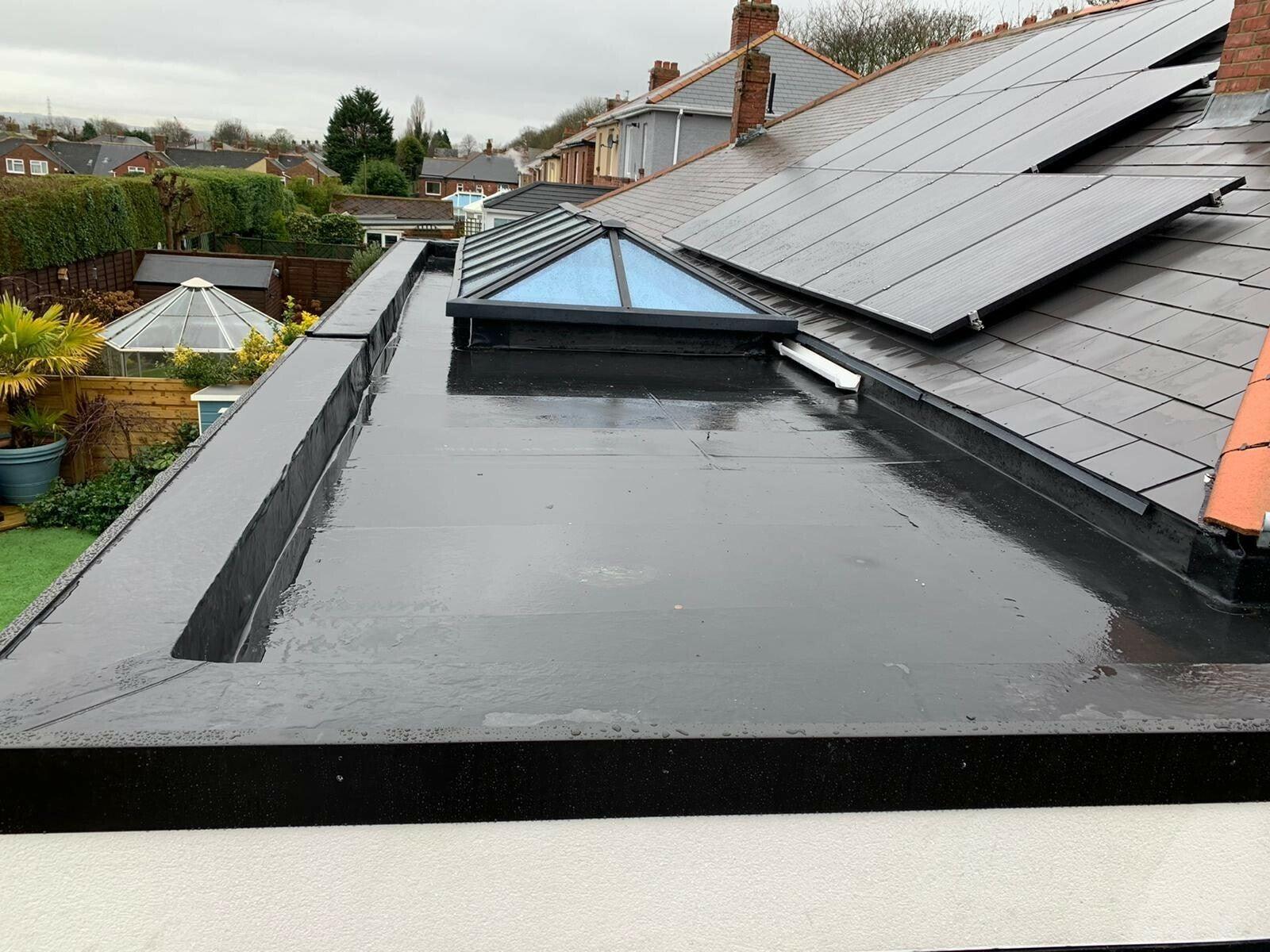 EPDM flat roof with solar panels beside red tiles