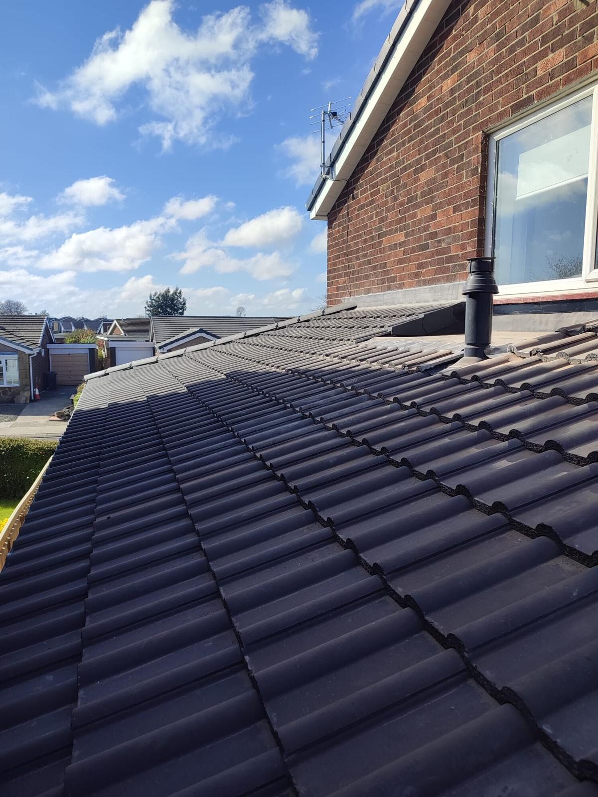 new dark tiled bungalow roof, deep blue sky — recent Willow Roofing work