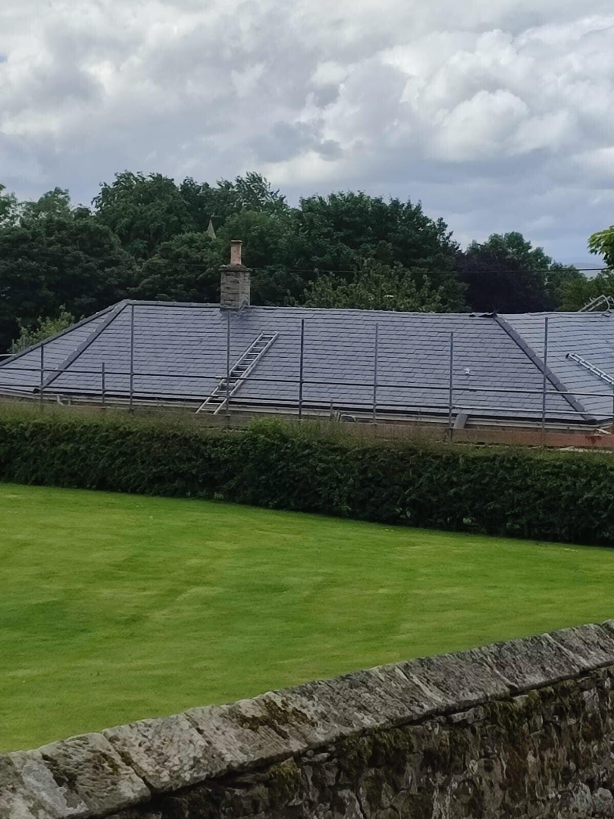 long slate bungalow roof across lawn, wide
