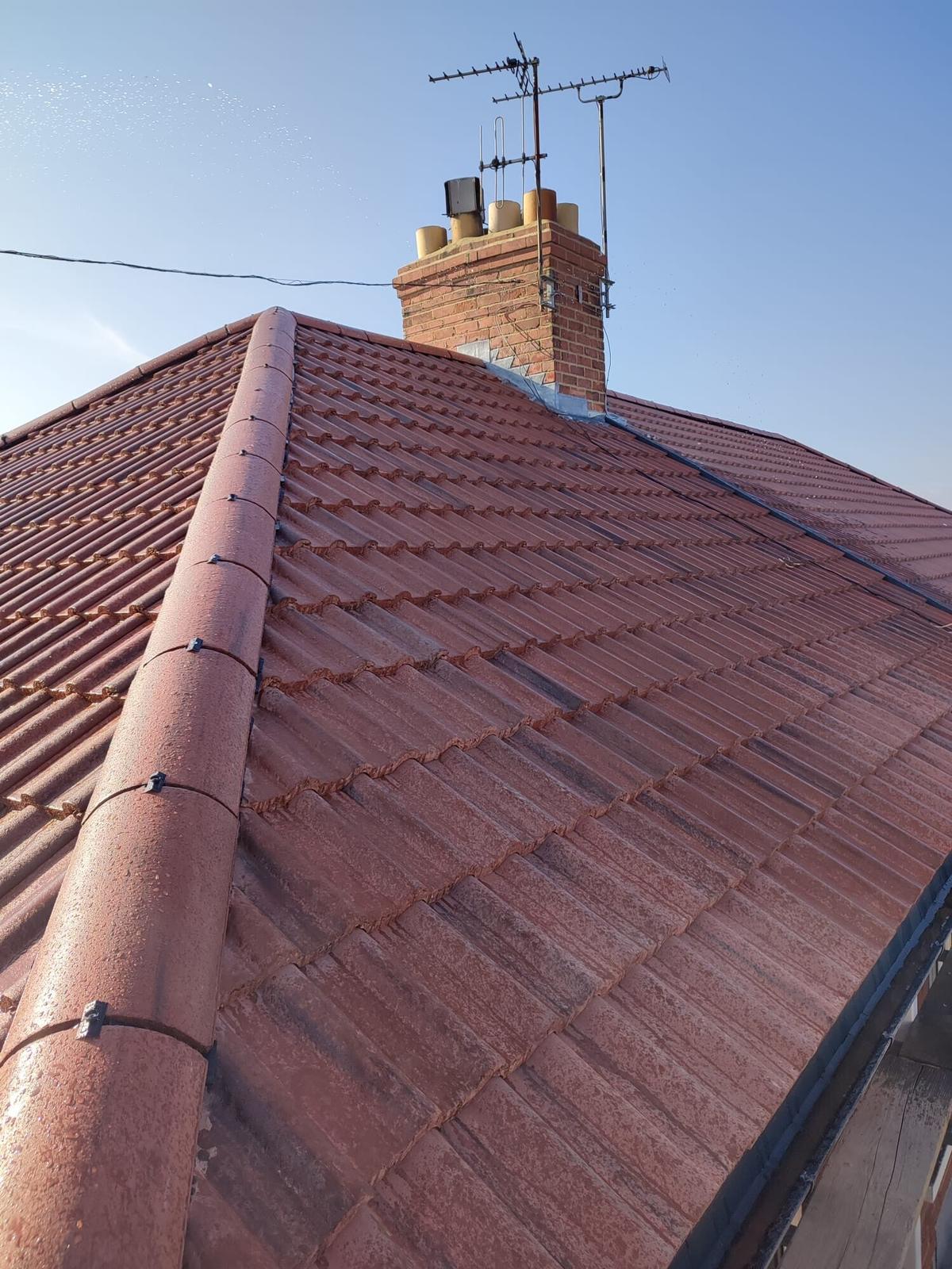 steep new red pantile roof and chimney, wet sheen