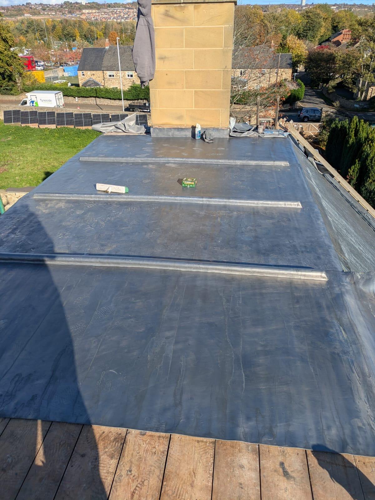 new lead-covered roof with wood-cored rolls dressed to the chimney stack, from above