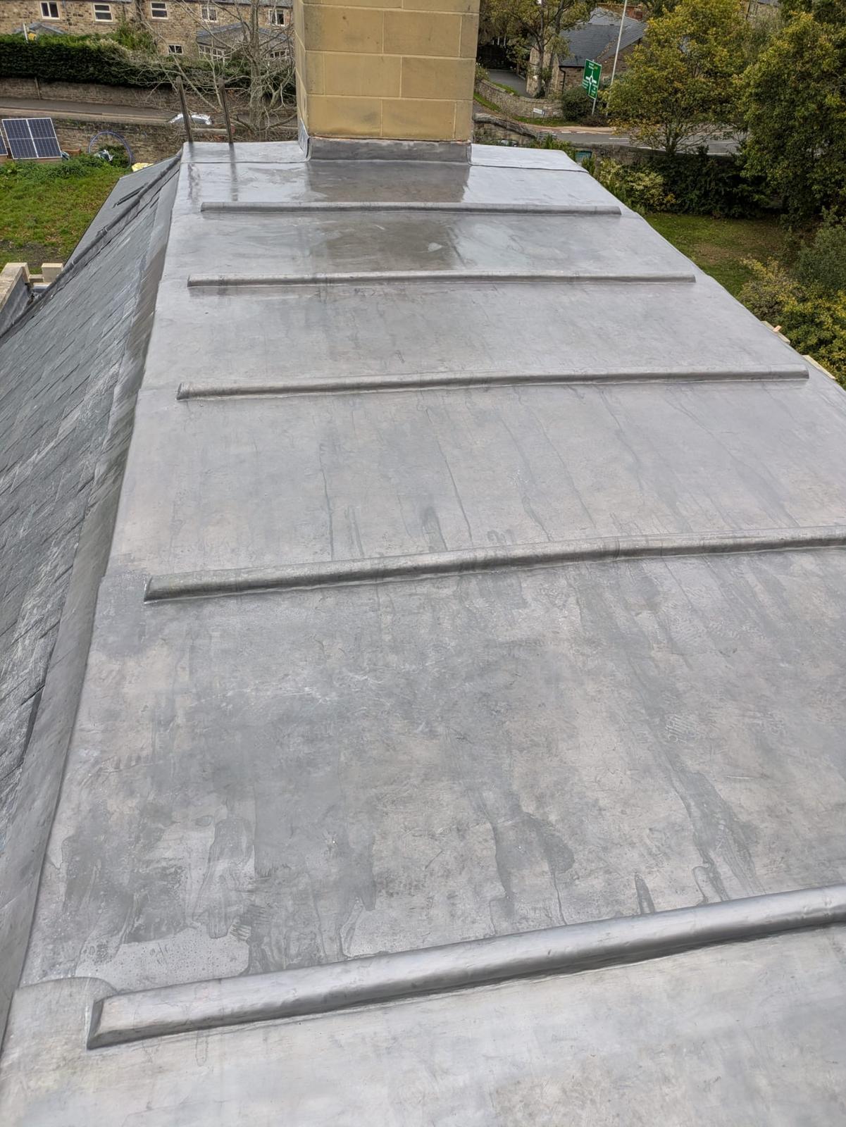 finished lead roof, crisp rolls and welted drips against the stack