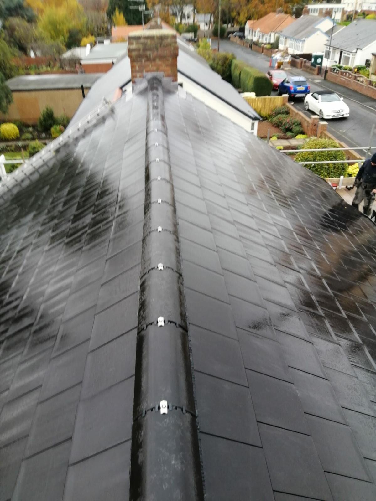 Dry ridge system with mechanical clips running the full length of a new tiled roof