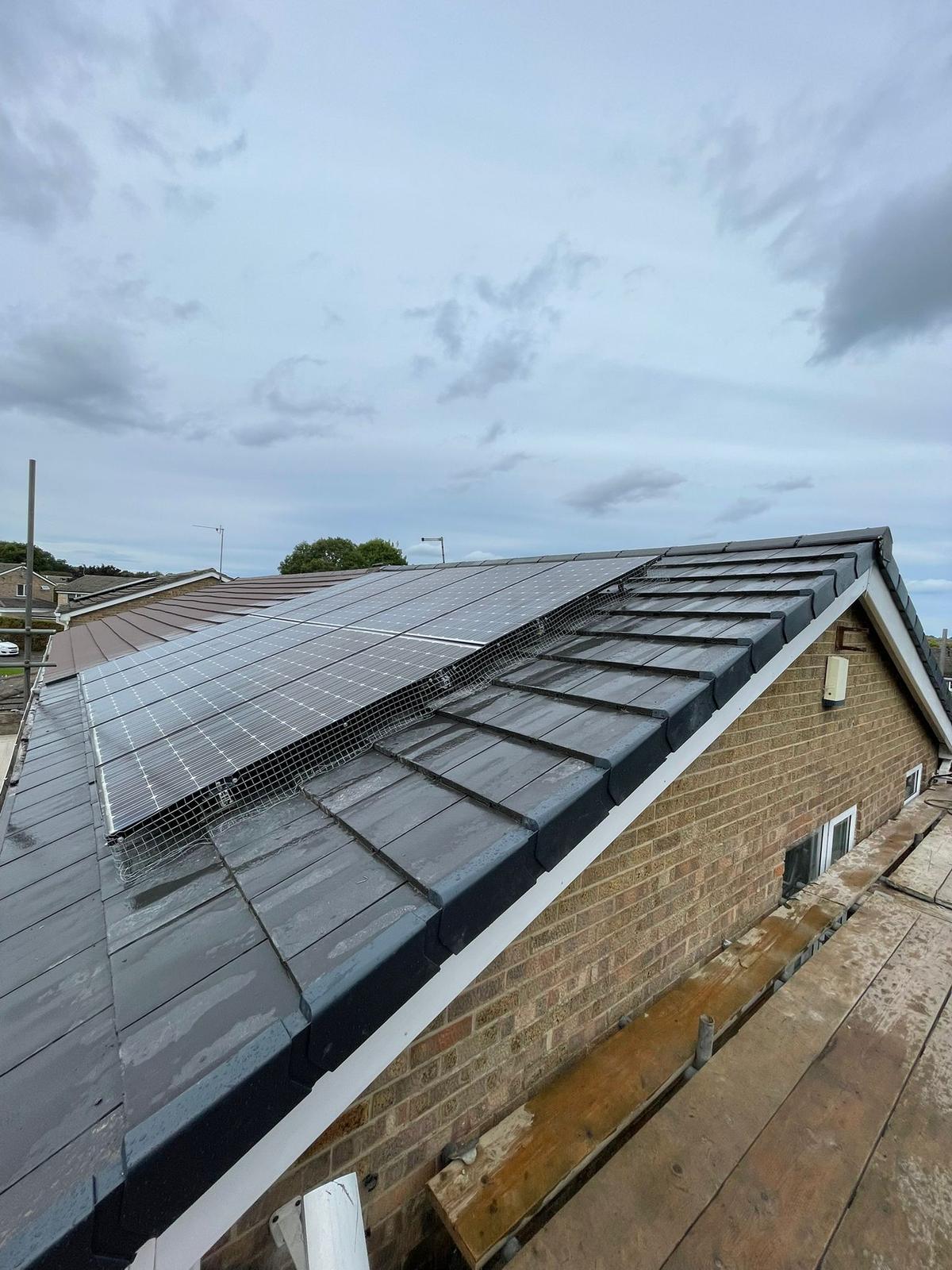 bungalow re-roofed in grey tiles with solar panels, from the gable, Washington