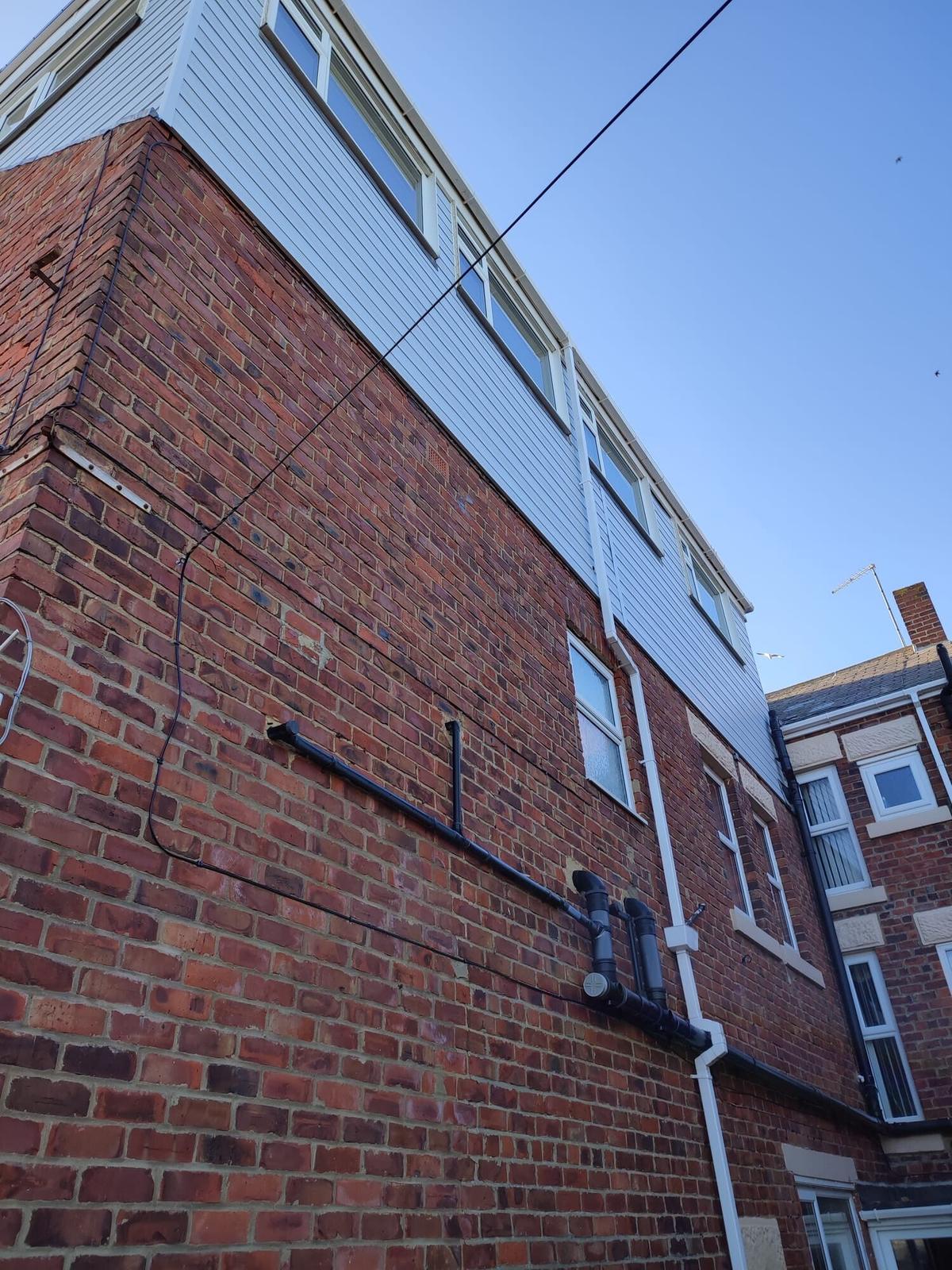 brick semi with new gable cladding, blue sky