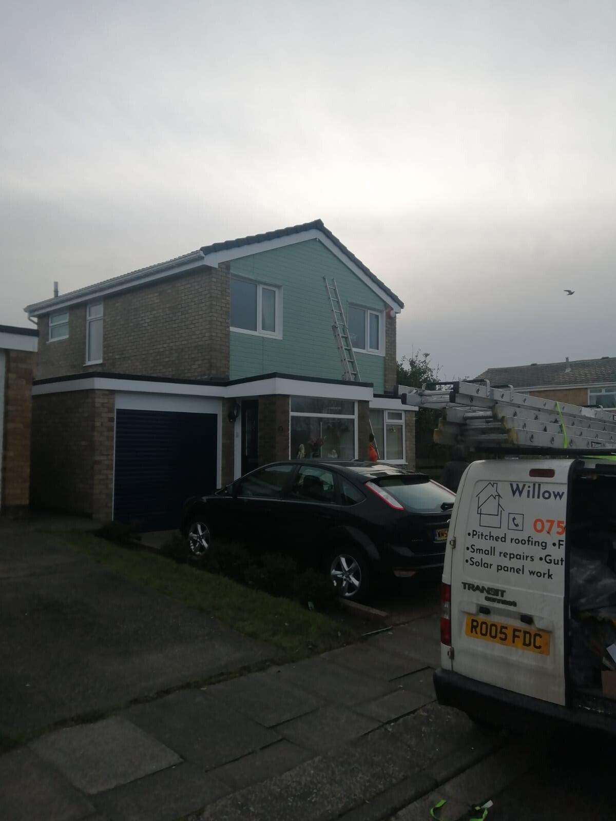 teal-clad house with branded van in drive — recent Willow Roofing work