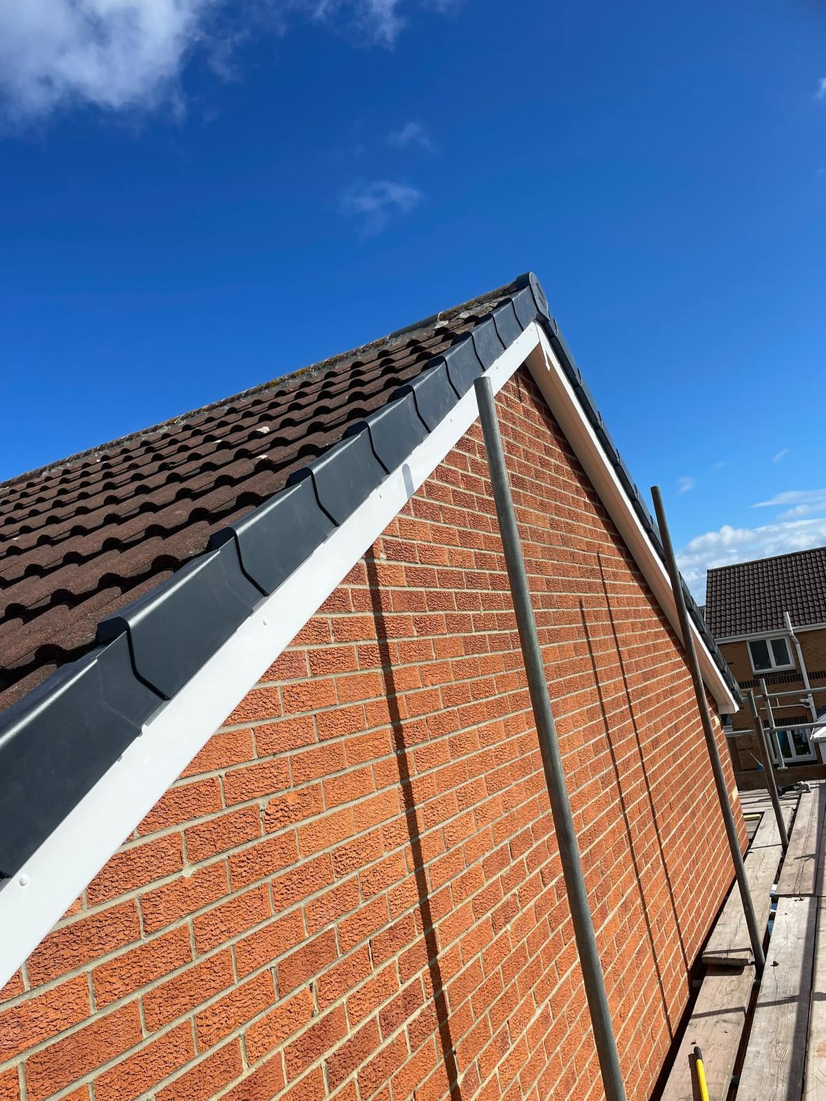 gable end with new white fascia, soffit and dry verge, blue sky, Cramlington
