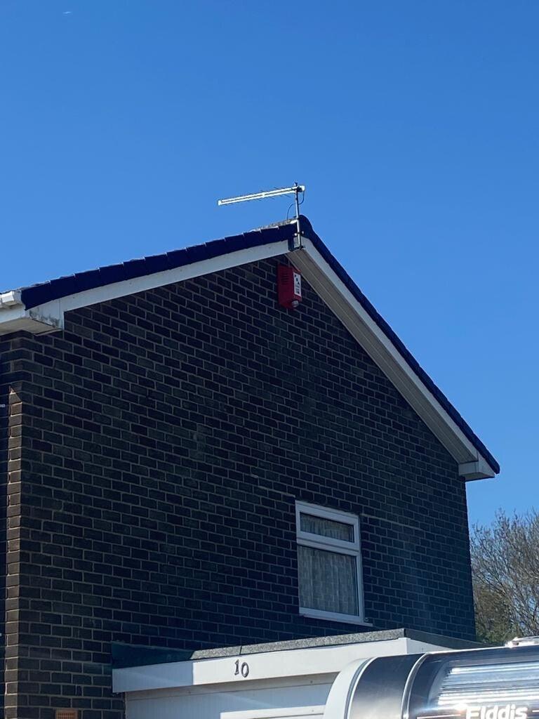 dark vertical cladding gable, white fascia, blue sky