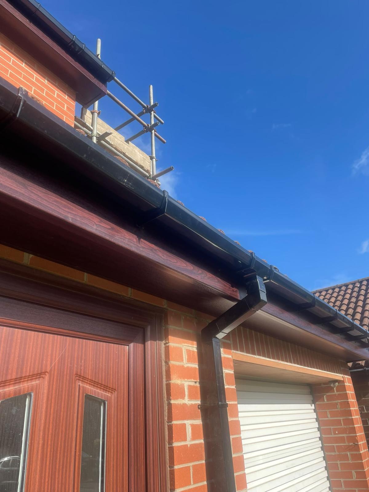 new rosewood fascia, soffit and black guttering above a garage, Killingworth